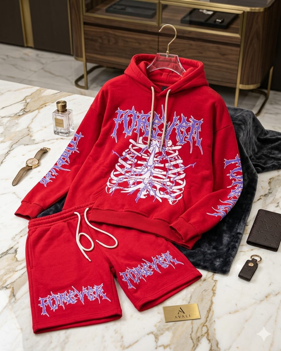 Bold oversized two-piece matching sweatsuit set featuring a gothic metal-style Forever text graphic and detailed skeleton ribcage print on the hoodie chest, with matching Forever lettering down both sleeves and across the shorts. Pullover hoodie with drawstring and kangaroo pocket paired with drawstring fleece shorts. Available in red with purple graphic and all black with purple graphic. Heavyweight fleece fabric perfect for streetwear, casual outings, or statement fashion styling.