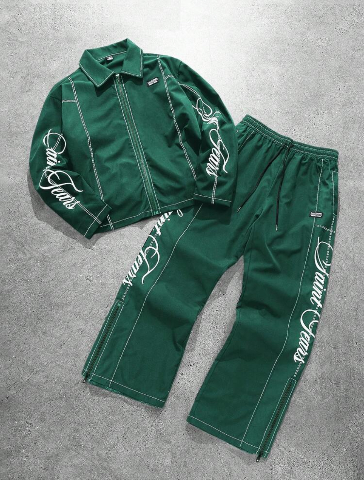 Premium Off-White Cream Structured Faux-Leather Zippered Track Jacket and Matching Wide-Leg Adjustable Drawstring Track Pants Two-Piece Co-ord Streetwear Set Featuring Intricate Contrast Topstitching and Elegant Vertical Black Calligraphy "Saint Tears" Script Graphic Embroidery