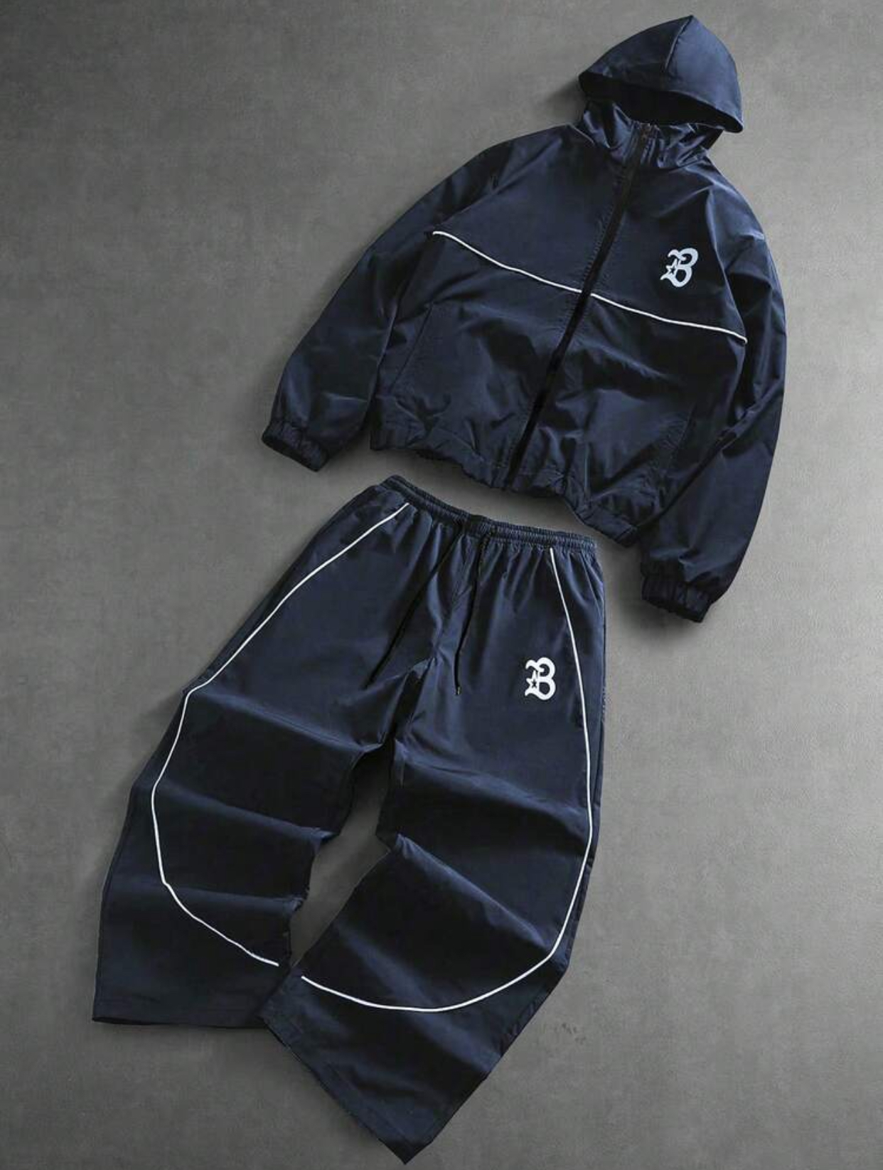 Deep Slate Blue Weather-Resistant Functional Hooded Windbreaker Utility Jacket and Relaxed Baggy Track Pants Athleisure Tracksuit Set Featuring Minimalist White Contour Piping Accents and Stylized Old English Varsity Letter "B" Monogram Logo 2