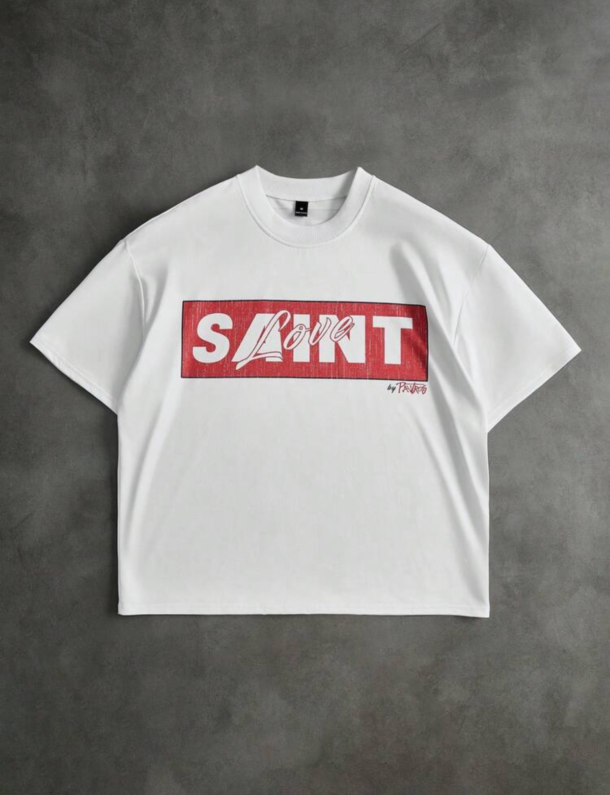 Urban Streetwear White Boxy T-Shirt Featuring a Distressed Red Rectangular Box Graphic with Stenciled Bold "SAINT" Lettering Overlaid by Cursive "Love" Typography