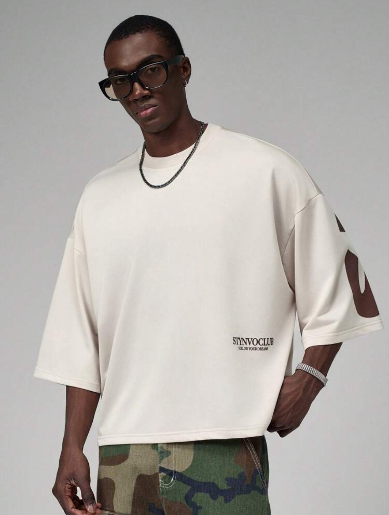 Premium Heavyweight Off-White Boxy Streetwear T-Shirt Lower Profile Highlight Featuring Clean Dark Brown "STYNVOCLUB FOLLOW YOUR DREAMS" Side-Hem Serif Typography