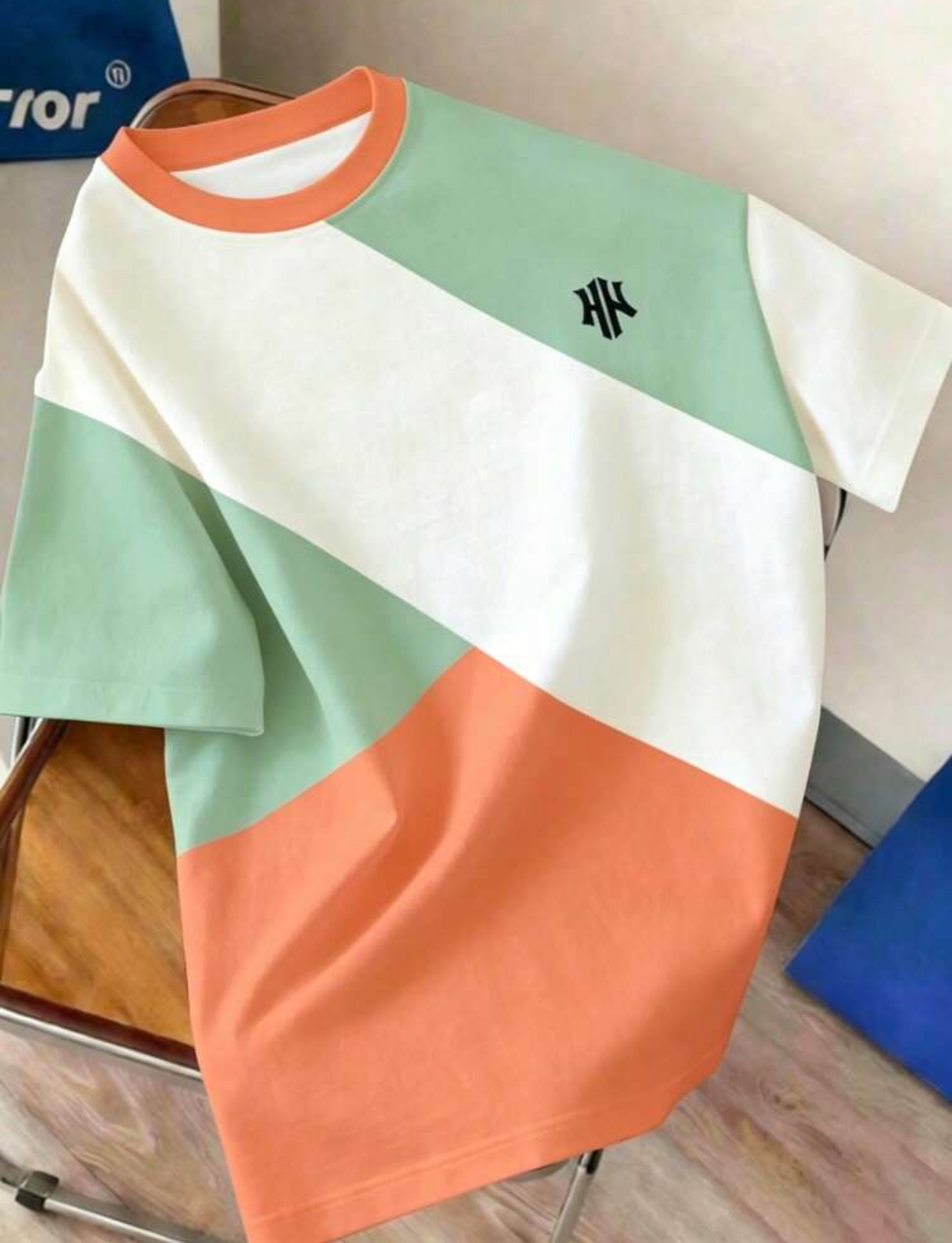 Retro 90s Geometric Color-Blocked Boxy T-Shirt Featuring Asymmetric Diagonal Panels of Soft Sage Green, Vibrant Pastel Orange, and Crisp White with a Coordinating Orange Ribbed Collar 3
