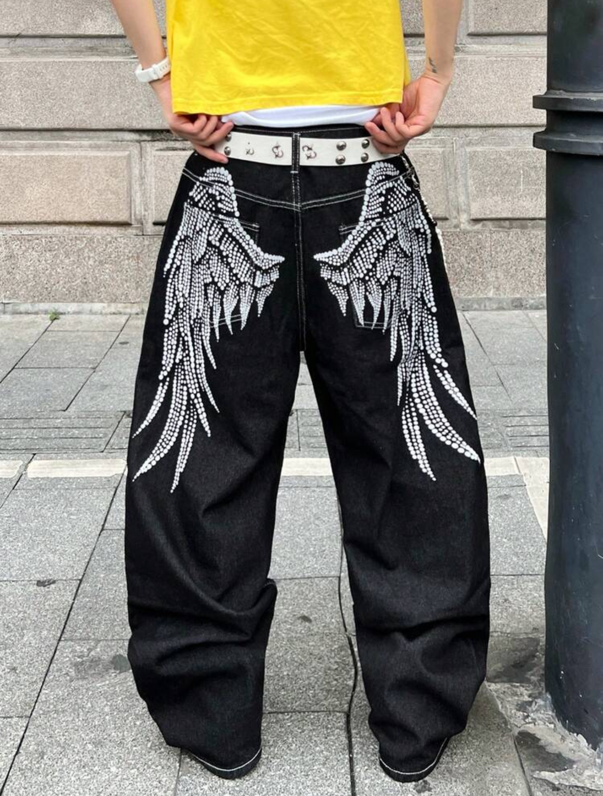 Y2K Gothic-Revival Baggy Off-White Denim Trousers Detailed with Large Back-Pocket Black Rhinestone Fallen Angel Wing Graphics and a Studded Leather Belt 2